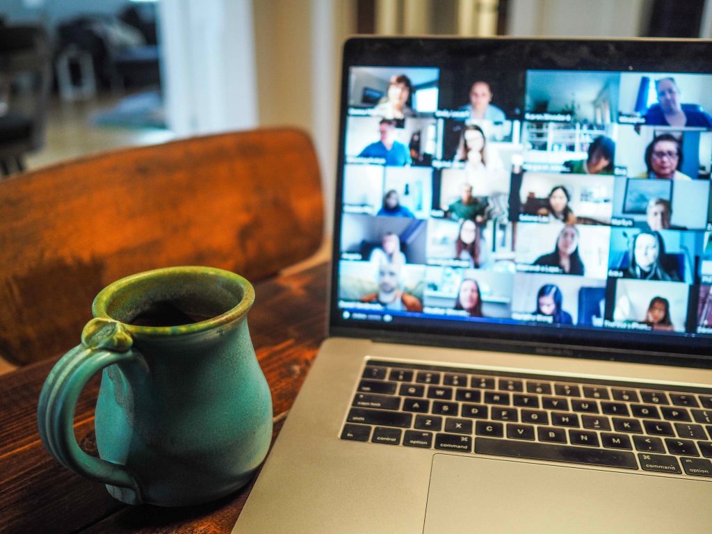 Mug next to a laptop showing Zoom call.